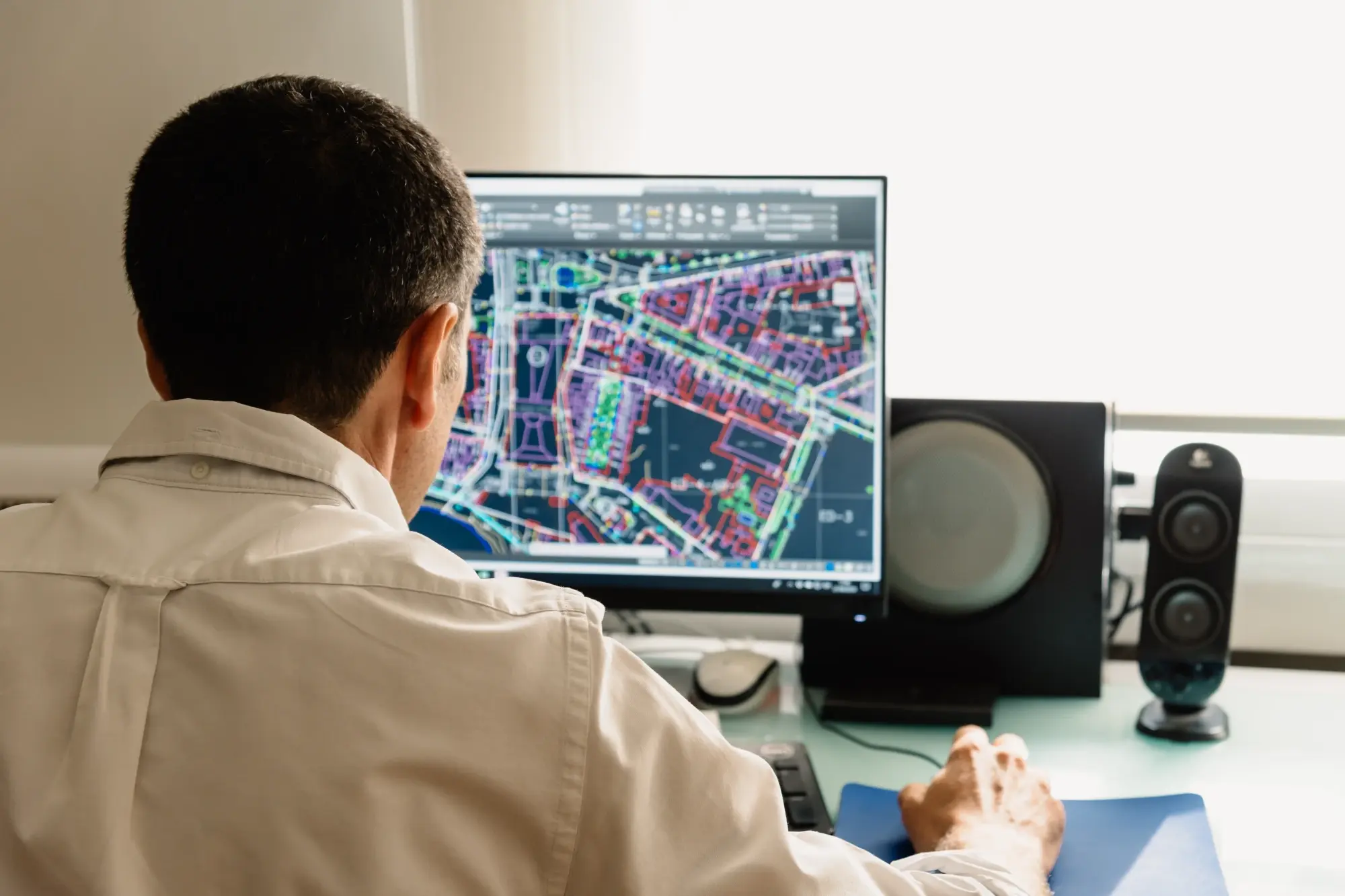 Technician reviewing color-coded parcel and infrastructure data in GIS mapping software