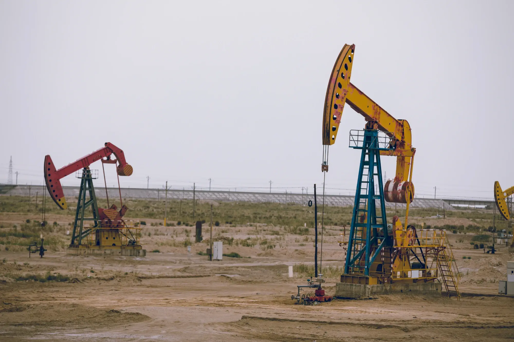 Pump jacks operating on an arid West Texas well site supported by oil and gas surveying services