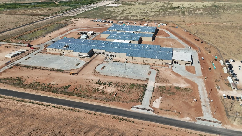 Midland County Detention Facility: Full campus from the south, showing the housing wings, service buildings, and finished perimeter fencing.