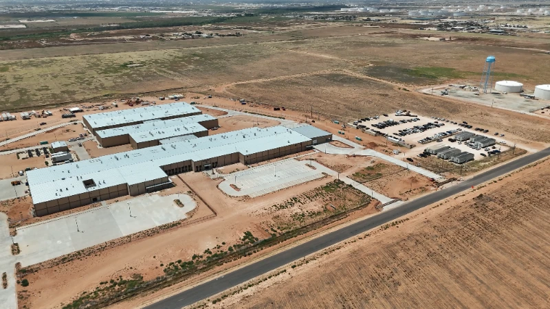 Midland County Detention Facility: Aerial view of the completed campus with paved drives, parking, and the perimeter road in place.