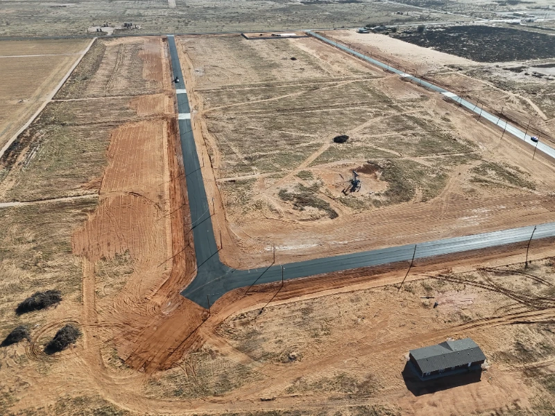 Pony Express Subdivision: Streets paved and curbed, lots graded, and the first home under construction at the corner.