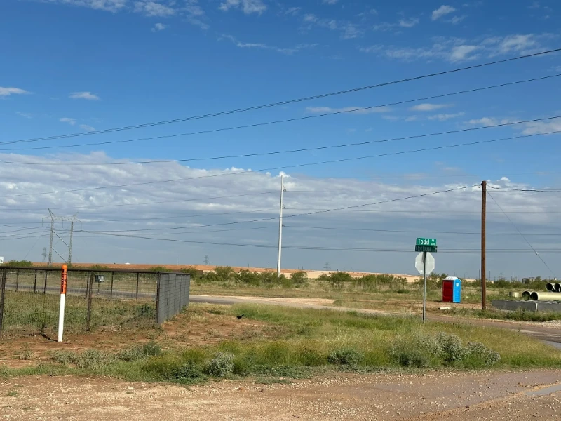 Todd Road Waterline Survey and SUE: The Todd Drive corridor with overhead transmission lines and staged pipe along the proposed alignment.